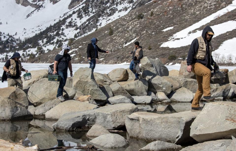 Fishermen walk along a rock jetty at the Convict Lake marina in Convict Lake.