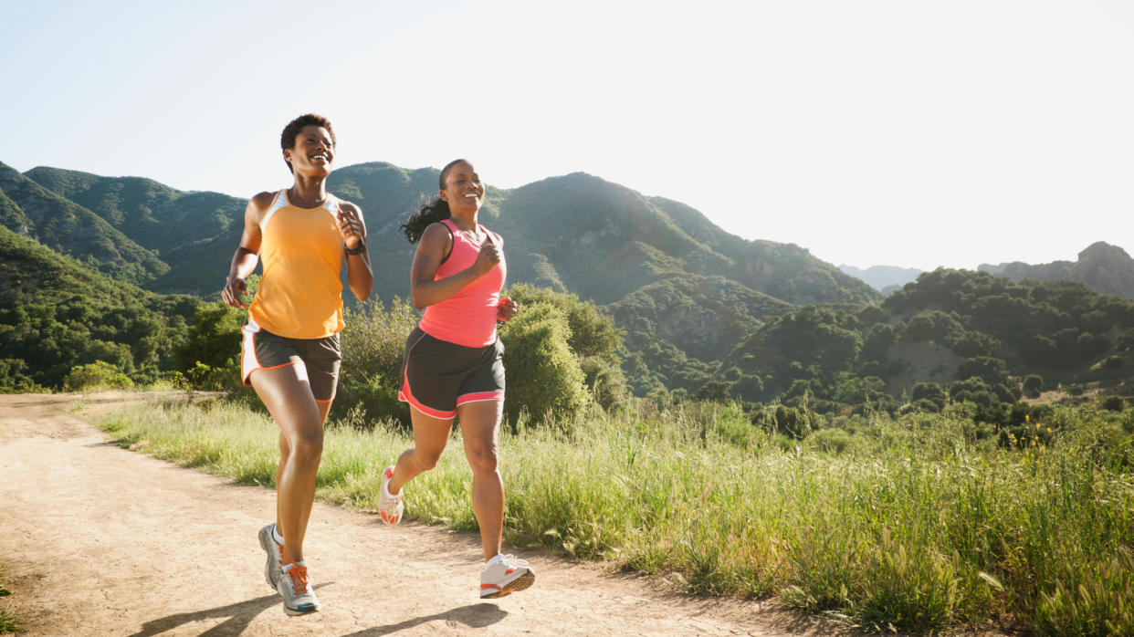  Women in shorts running on a trail. 