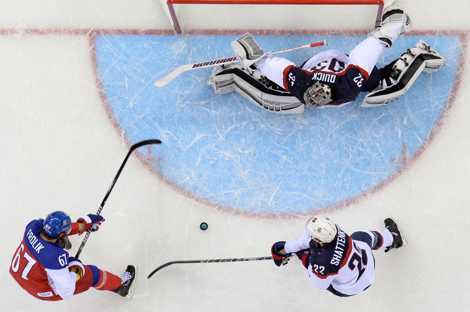 Czech Republic's Michael Frolik (L) vies with US Kevin Shattenkirk in front of US goalkeeper Jonathan Quick (top) during the Men's Ice Hockey Quarterfinals match between the USA and the Czech Republic, at the Shayba Arena during the Sochi Winter Olympics on Feb. 19, 2014. 