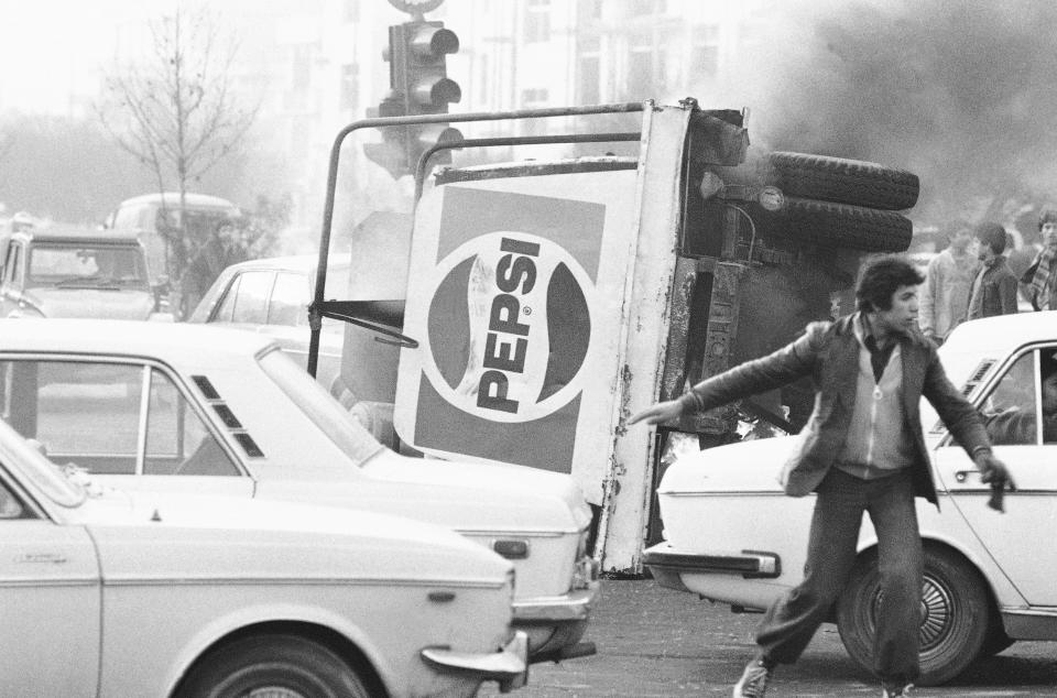 FILE - In this Dec. 27, 1978 file photo, an overturned truck with a Pepsi soft drink logo burns during riots in Tehran, Iran. Forty years ago, Iran's ruling shah left his nation for the last time and an Islamic Revolution overthrew the vestiges of his caretaker government. The effects of the 1979 revolution, including the takeover of the U.S. Embassy in Tehran and ensuing hostage crisis, reverberate through decades of tense relations between Iran and America. (AP Photo, File)