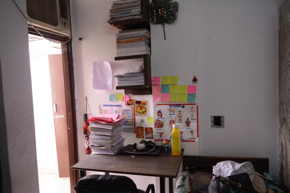 Books stacked on a student’s study table in their hostel room (Namita Singh/The Independent)