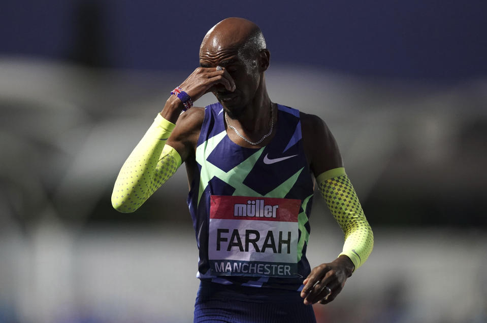 Britain's Mo Farah reacts after failing to achieve the qualifying time in the Men's 10000m final during day one of the British Athletics Championships at Manchester Regional Arena in England, Friday June 25, 2021. Mo Farah failed to qualify for the Tokyo Olympics and will not defend his 10,000-meter title. The four-time Olympic champion missed the qualifying time in an invitational 10,000 at the British athletics championships in Manchester. (Martin Rickett/PA via AP)