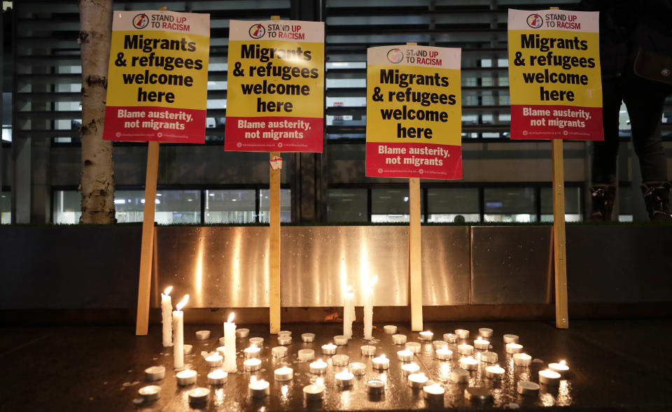 Signs and candles on a wall were placed at a vigil for the 39 lorry victims, outside the Home Office in London, Thursday, Oct. 24, 2019. Authorities found 39 people dead in a truck in an industrial park in England on Wednesday and arrested the driver on suspicion of murder in one of Britain's worst human-smuggling tragedies. (AP Photo/Kirsty Wigglesworth)