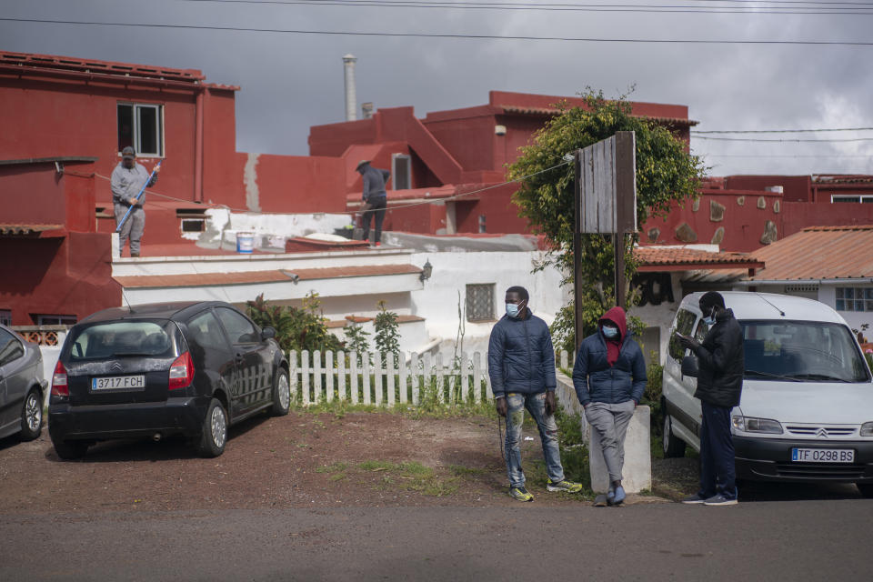 Migrants from Senegal, wait for donated clothes and food near Las Raices camp in San Cristobal de la Laguna, in the Canary Island of Tenerife, Spain, Friday, March 19, 2021. Several thousand migrants have arrived on the Spanish archipelago in the first months of 2021. Due to the terrible living conditions and the poor quality of food and water at the Las Raices camp, some migrants have decided to leave the camp and sleep in shacks in a nearby forest instead. (AP Photo/Joan Mateu)