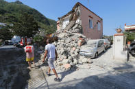 <p>People walk near an house destroyed in the earthquake in one of the more heavily damaged areas on Aug. 22, 2017 in Casamicciola Terme, Italy. (Photo: Marco Cantile/NurPhoto via Getty Images) </p>