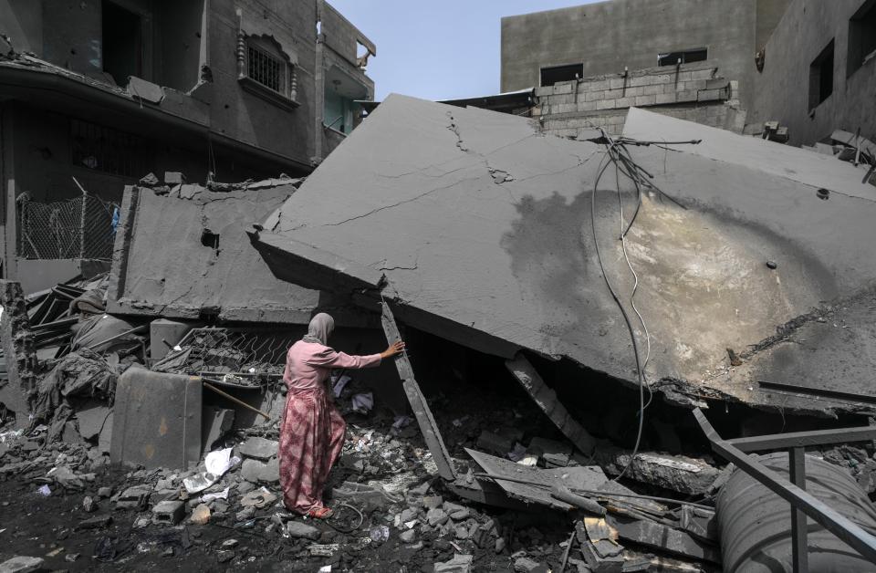A Palestinian woman looks at the damges at her destroyed family house following an Israeli air strike in Al Maghazi refugee camp, southern Gaza Strip (EPA)