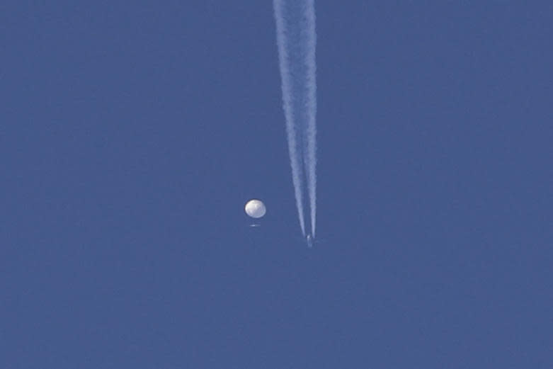 In this photo provided by Brian Branch, a large balloon drifts above the Kingston, N.C. area, with an airplane and its contrail seen below it.  / Credit: Brian Branch / AP