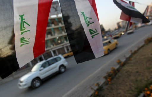 Cars drive past Iraqi flags decorating a street in the capital Baghdad to mark the withdrawal of US troops from Iraq. The secular Iraqiya bloc, which won most of the votes of Iraq's disenchanted Sunni Arab minority, has walked out of parliament sparking a political crisis days after US forces ended their mission