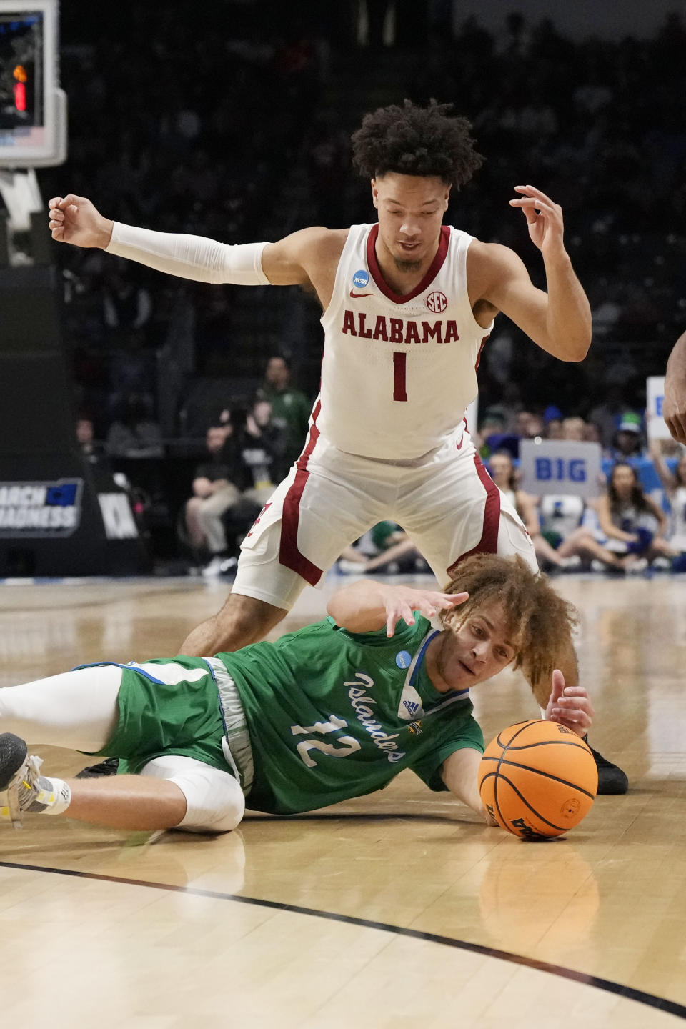 Texas A&M Corpus Christi forward Owen Dease (12) reaches for the ball while Alabama guard Mark Sears (1) defends in the first half of a first-round college basketball game in the NCAA Tournament in Birmingham, Ala., Thursday, March 16, 2023. (AP Photo/Rogelio V. Solis)