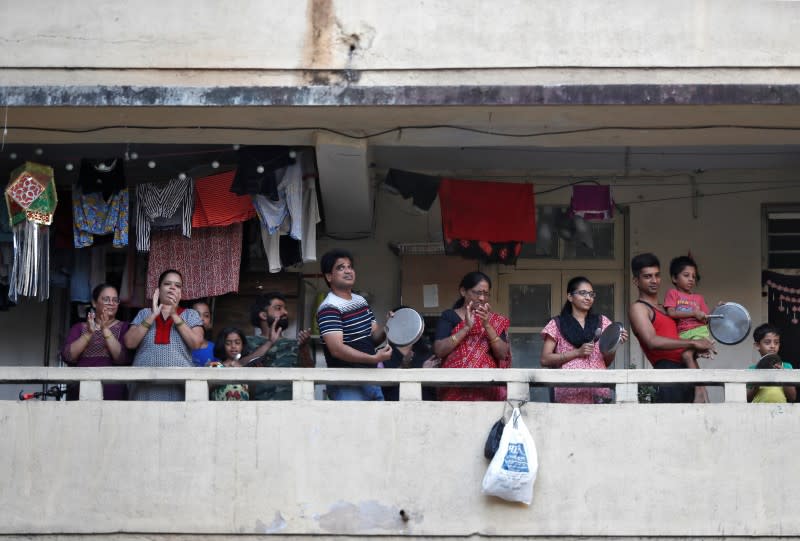 Residents clap and bang utensils from their balconies to cheer for emergency personnel and sanitation workers who are on the frontlines in the fight against coronavirus, in Mumbai