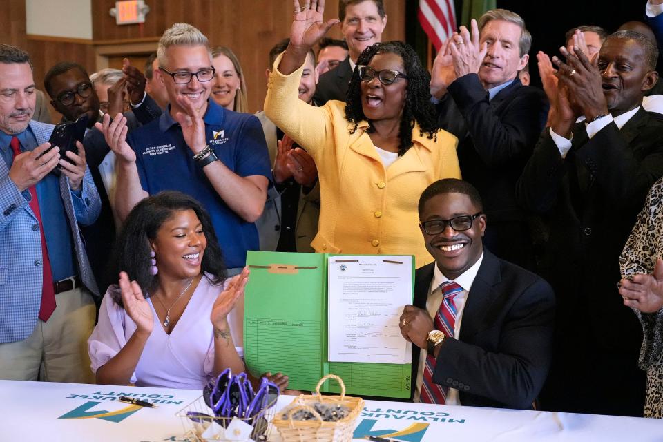 Milwaukee County Board Chairwoman Marcelia Nicholson, left, celebrates with others while Milwaukee County Executive David Crowley, right, holds up the sales tax increase document that was signed by him and Nicholson on Thursday, Aug. 3, 2023, at the Washington Park Senior Center at 4420 W. Vliet St. Also part of the celebration is Congresswoman Gwen Moore, center standing.