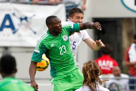 Nigeria forward Shola Ameobi (23) and United States defender Matt Besler (5) miss the header during the first half at EverBank Field. Mandatory Credit: Kim Klement-USA TODAY Sports