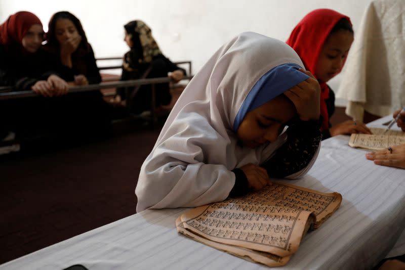 An Afghan girl reads the Koran in a madrasa or religious school in Kabul