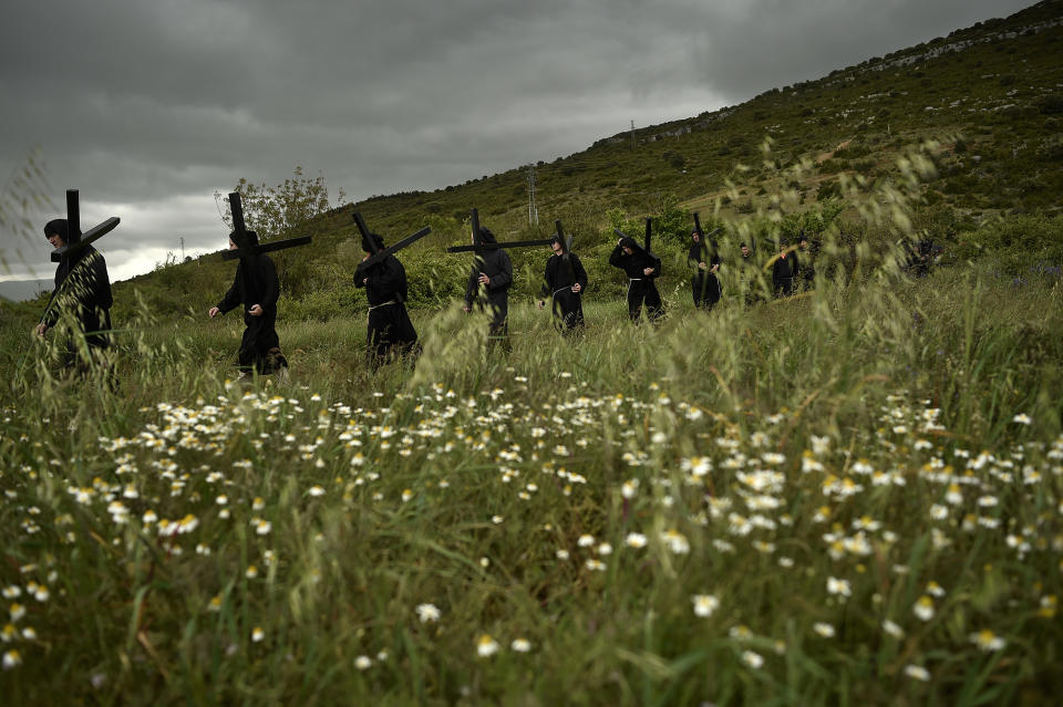 <p>Devotes walk through a field holding their crosses during a march of the ”Romeros de Lumbier” near to the small village of Lumbier, northern Spain, May 22, 2016. Every year devotees march from their small town to a Trinity Chapel in the top of the hill where they receive a blessing. (Alvaro Barrientos/AP) </p>