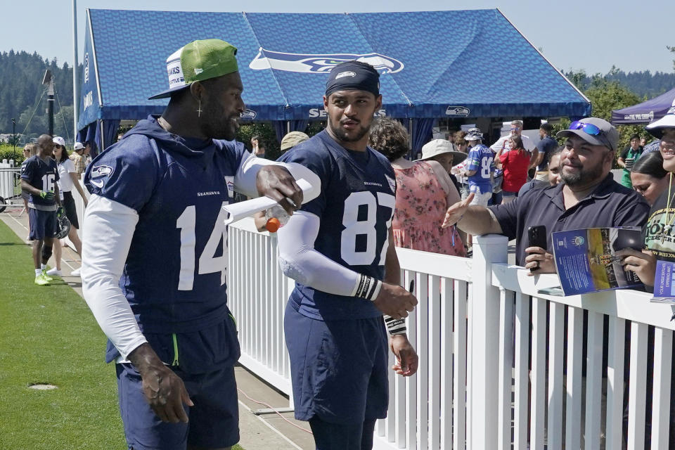 Seattle Seahawks wide receiver DK Metcalf, left, walks with tight end Noah Fant (87) after practice at NFL football training camp Thursday, July 28, 2022, in Renton, Wash. (AP Photo/Ted S. Warren)