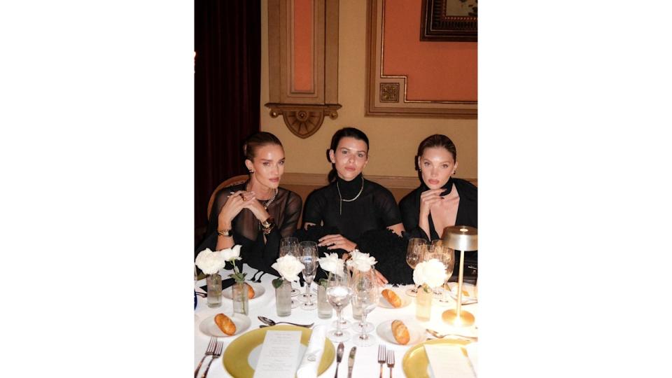 Rosie Huntington Whiteley, Georgia Fowler and Elsa Hosk all sit next to each other in black dresses at a Tiffany & Co. dinner