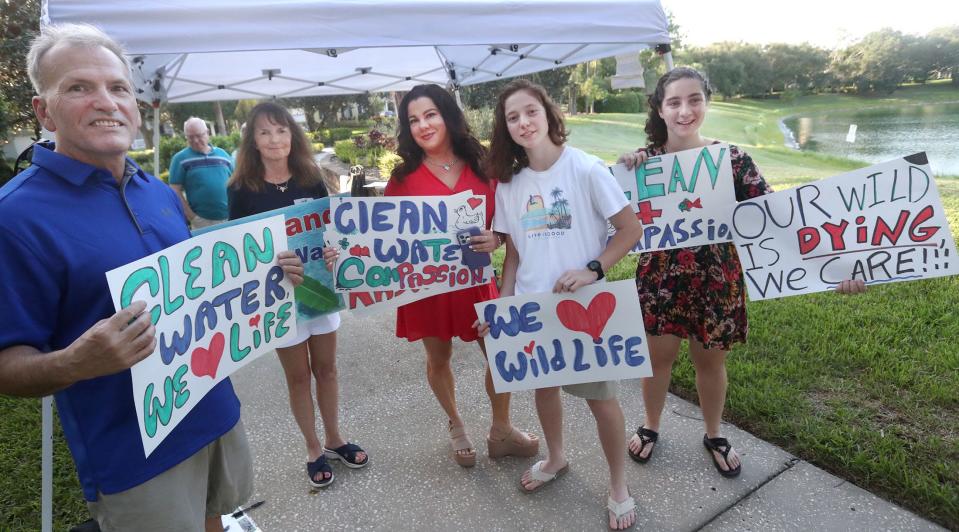 Residents and environmental activists, from left, Vincent Thouin, Suzanne Schriber, Raquel Levy, Bella Schwartz and Alexa Schwartz, demonstrate at the lake in the Victoria Lake development in DeLand, Wednesday, July 24, 2024, following a number of wildlife deaths.