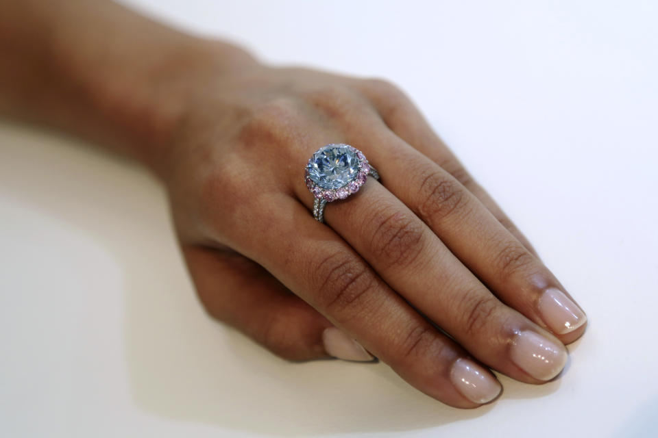 Sotheby's employee models a 7.59-carat internally flawless blue diamond at their New York auction house, Wednesday, Sept. 4, 2013 in New York. Sotheby's also had on display a 118-carat white diamond that will be auctioned in Hong Kong on Oct. 7 and has a pre-sale estimate of $28 million to $35 million. (AP Photo/Mary Altaffe)