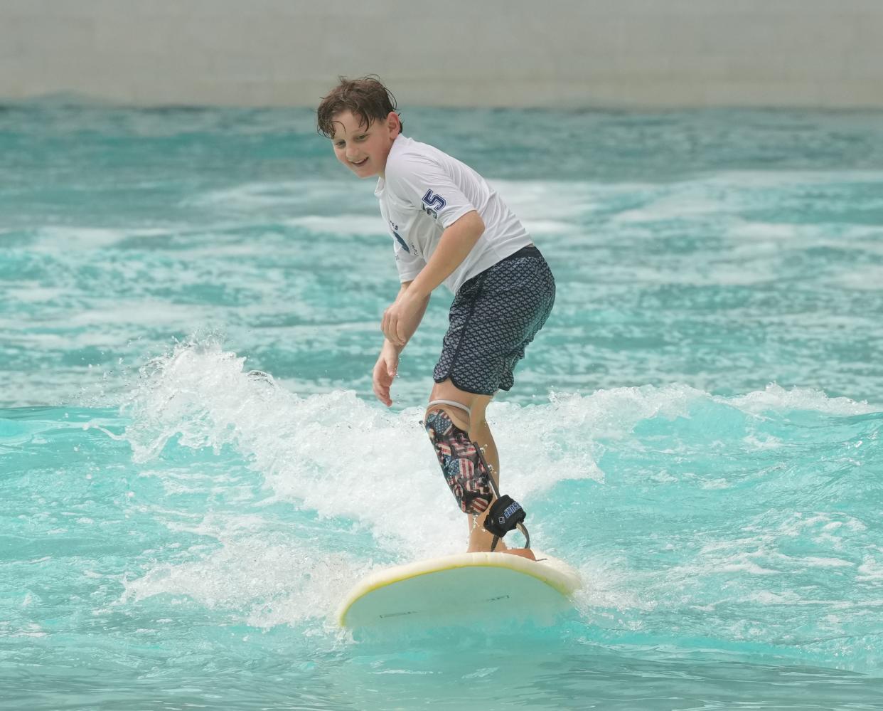 Paramus' Gio DiPersia, 11, participated in the Challenged Athletes Foundation surfing clinic at American Dream's Dreamworks Waterpark. He hopes new legislation will help his family afford a prostheses specially designed for athletic competition.