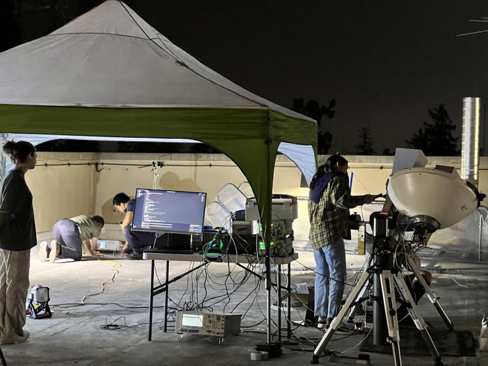 scientists with a power receiver on a rooftop to detect solar power from space