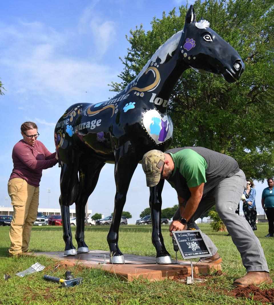 Bethany and Chris Tolley install the new Lauren Landavazo memorial horse at McNiel Middle School as shown in this May 27, 2021, file photo. Bethany is the artist that recreated the design of the previous horse painted by Ronda Ivy. The original horse was stolen in October 2020.