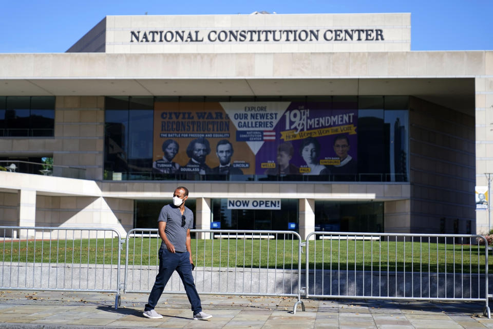 FILE—In this file photo from Oct. 15, 2020, a man walks past the National Constitution Center in Philadelphia. The facade bearing the First Amendment of the U.S. Constitution that was on the front of the Newseum in Washington that closed in December of 2019, will be reinstalled at The National Constitution Center in an atrium overlooking Independence Hall.(AP Photo/Matt Slocum, File)