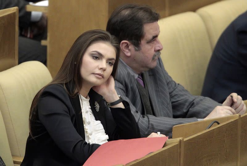 FILE PHOTO: Deputy Chairman of State Duma Committee for Youth Affairs and member of United Russia party Kabaeva listens to Russia's PM Putin speaking at parliament at State Duma in Moscow