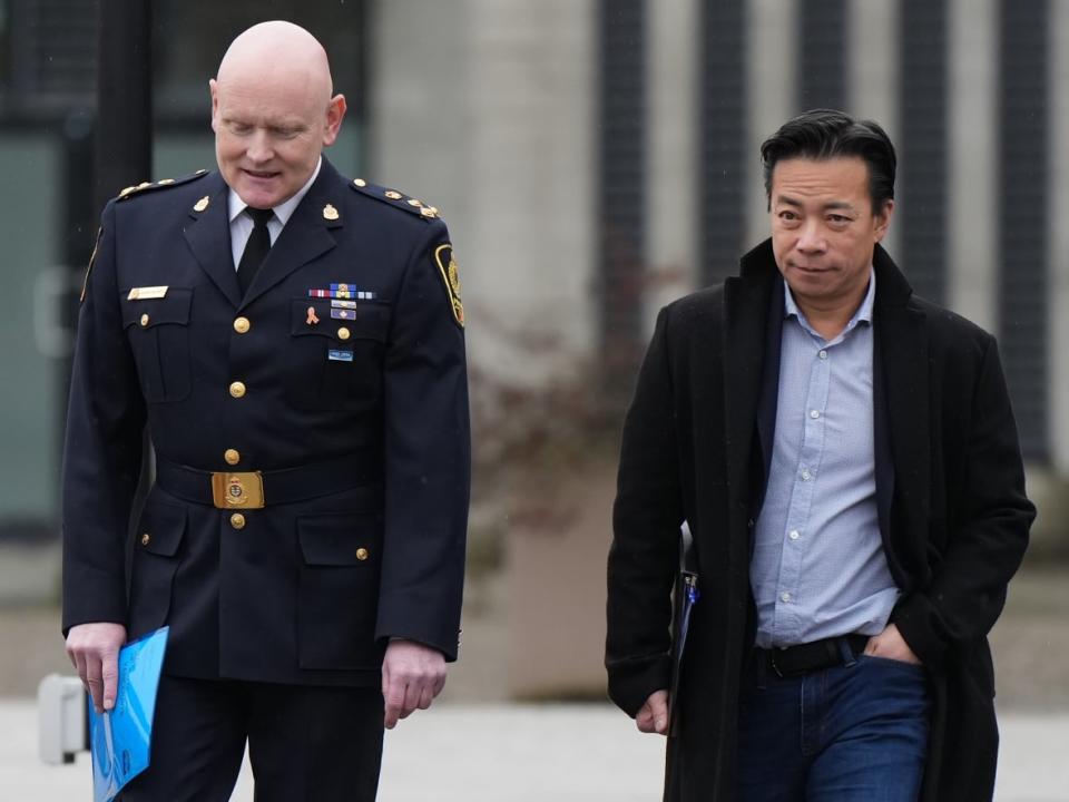 Vancouver Police Chief Adam Palmer, left, and Mayor Ken Sim, arrive for a news conference, in Vancouver, on Sunday, February 5, 2023. The City of Vancouver has announced $2.8 million in funding for Vancouver Coastal Health to bolster mental health outreach teams. (Darryl Dyck/the Canadian Press - image credit)