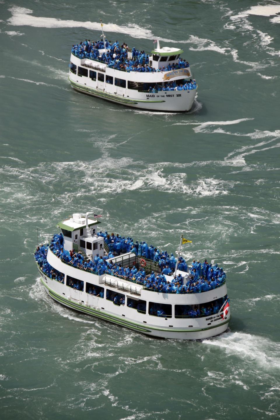 FILE - In this June 11, 2010 file photo, tourists ride the Maid of the Mist tour boats in Niagara Falls, N.Y. The tour company chosen to take over the Niagara Falls tour boat business in Canada says it plans to build customized new boats and upgrade amenities while maintaining the things that have made the sightseeing rides so popular for more than 100 years. (AP Photo/David Duprey, File)