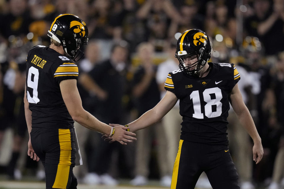 Iowa place-kicker Drew Stevens (18) celebrates with teammate Tory Taylor (9) after kicking a 34-yard field goal during the second half of an NCAA college football game against Michigan State, Saturday, Sept. 30, 2023, in Iowa City, Iowa. Iowa won 26-16. (AP Photo/Charlie Neibergall)