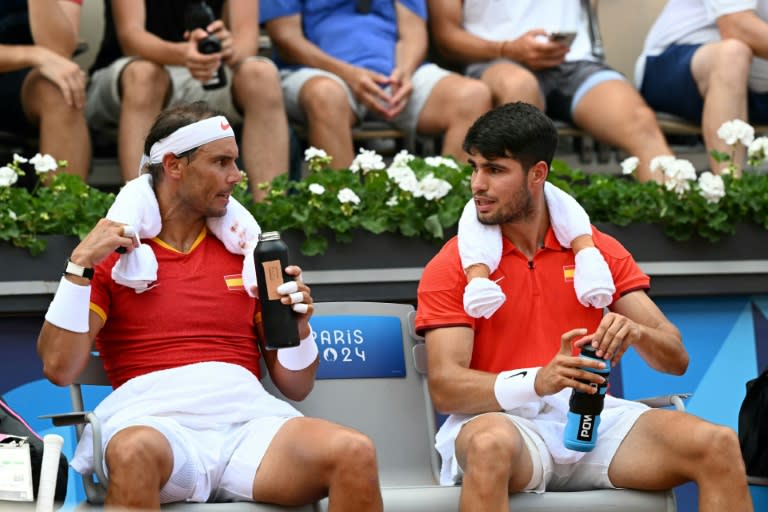 Los españoles Rafael Nadal (izq) y Carlos Alcaraz (derecha) hablan durante el duelo de dobles ante los jugadores neerlandeses Tallon Griekspoor y Wesley Koolhof en los Juegos Olimpicos de París el 30 de julio de 2024. (MARTIN BERNETTI)