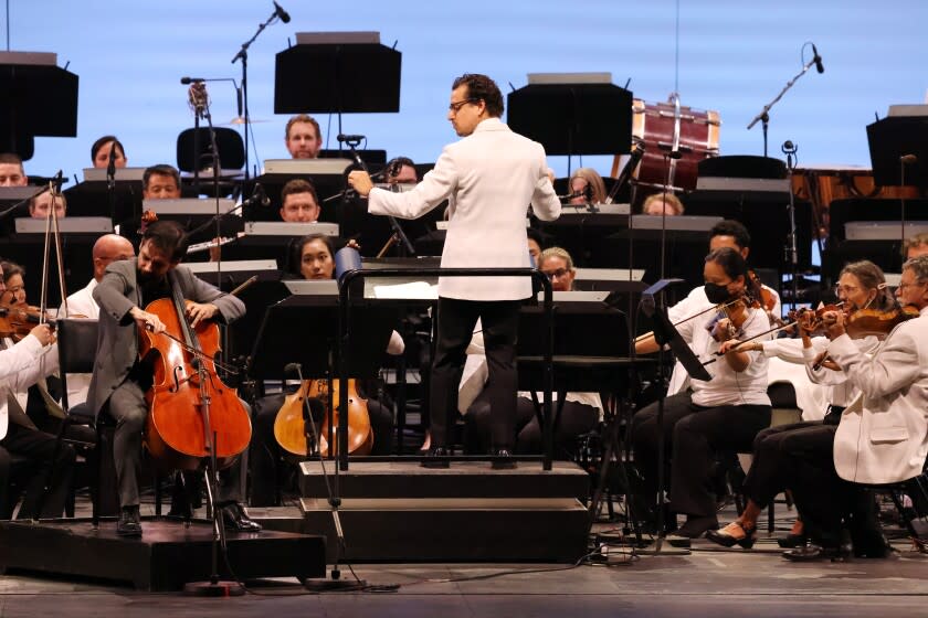 Los Angeles, CA - August 04: Cello soloist Pablo Ferrandez plays as conductor Paolo Bortolameolli, stands center, during a performance of The Splendor of Saint-Saens at the Hollywood Bowl on Thursday, Aug. 4, 2022 in Los Angeles, CA. (Dania Maxwell / Los Angeles Times)