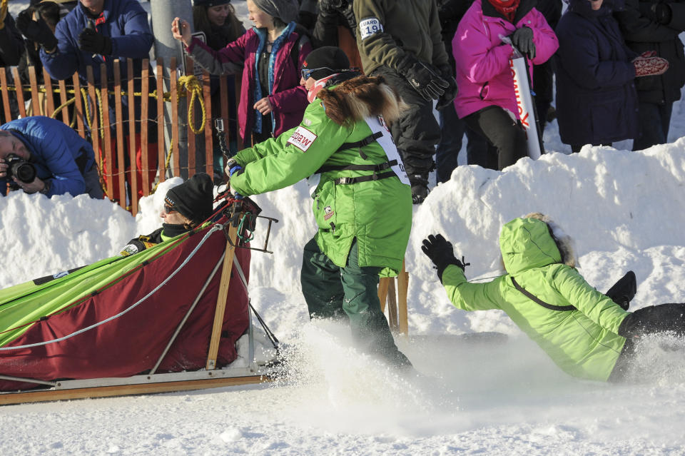 Iditarod musher Ryan Redington, left, loses his assistant as he rounds a turn during the ceremonial start of the Iditarod Trail Sled Dog Race Saturday, March 2, 2019 in Anchorage, Alaska. (AP Photo/Michael Dinneen)