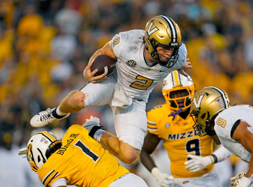 Vanderbilt quarterback Diego Pavia (2) leaps over Missouri safety Marvin Burks Jr. (1) during overtime.