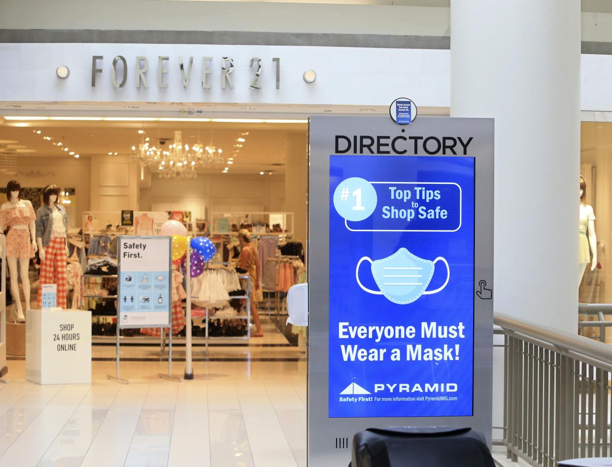 A sign on mask usage covers the disabled interactive directory display at the Poughkeepsie Galleria mall in Poughkeepsie, New York on July 10, 2020.