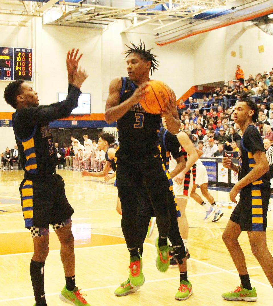 Simeon's Michael Ratliff grabs a rebound during the Wolverines' 52-49 win over Benet in the championship game of the Pontiac Holiday Tournament.