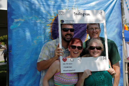 A group poses at a photo-booth in Carbondale, Illinois, U.S., August 20, 2017, one day before the total solar eclipse. REUTERS/Brian Snyder