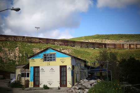 Carpenter Moses and dental assistant Sara's home stands near a section of the fence separating Mexico and the United States, in Tijuana, Mexico. REUTERS/Edgard Garrido