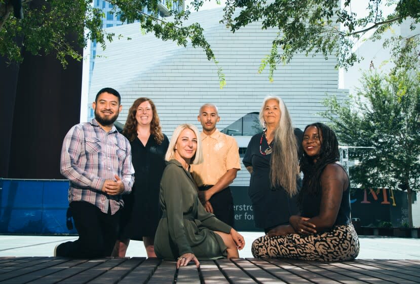 COSTA MESA, CA - AUGUST 03: Left to right: Artist Narsiso Martinez; Courtenay Finn, chief curator; Heidi Zuckerman, director; Alex Anderson, artist; Laurie Steelink, artist and Essence Harden, curator of the California biennial. Behind them is the Orange County Museum of Art which is near completion on Avenue of the Stars in Costa Mesa. Photographed on Wednesday, Aug. 3, 2022 in Costa Mesa, CA. (Myung J. Chun / Los Angeles Times)