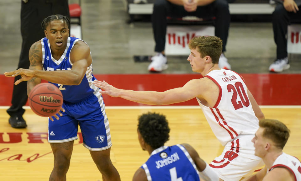 Eastern Illinois' Jordan Skipper-Brown (2) passes the ball past Wisconsin's Ben Carlson (20) during the first half of an NCAA college basketball game Wednesday, Nov. 25, 2020, in Madison, Wis. (AP Photo/Andy Manis)