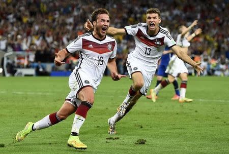 Germany's Mario Goetze (L) celebrates near teammate Thomas Mueller after scoring a goal during extra time in their 2014 World Cup final against Argentina at the Maracana stadium in Rio de Janeiro July 13, 2014. REUTERS/Dylan Martinez