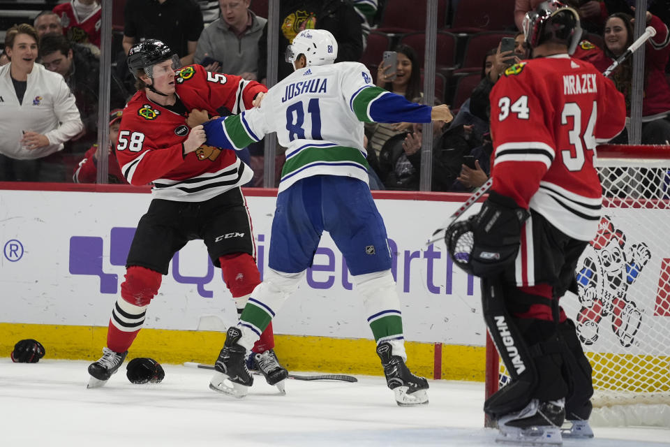 Chicago Blackhawks right wing MacKenzie Entwistle, left, and Vancouver Canucks center Dakota Joshua fight during the third period of an NHL hockey game, Tuesday, Feb. 13, 2024, in Chicago. The Canucks won 4-2. (AP Photo/Erin Hooley)