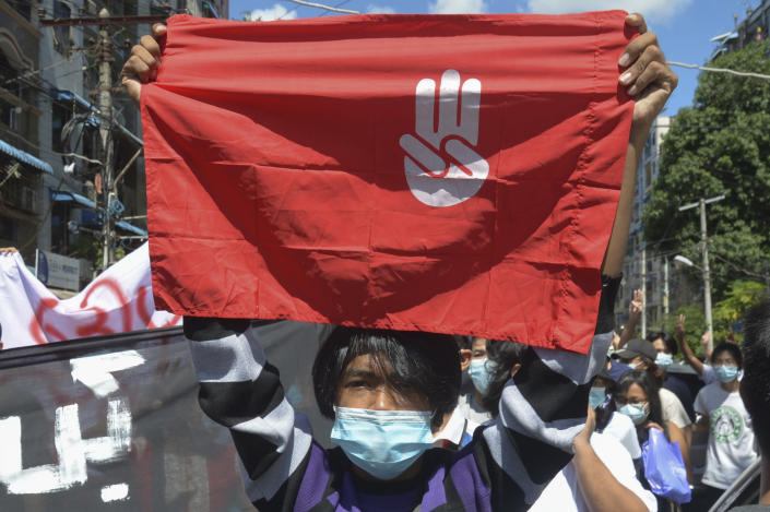 An anti-coup protester holds a slogan bearing the three-finger salute during a demonstration in Yangon, Myanmar on Tuesday May 11, 2021. The military takeover of Myanmar early in the morning of Feb. 1 reversed the country's slow climb toward democracy after five decades of army rule. But Myanmar's citizens were not shy about demanding their democracy be restored. (AP Photo)