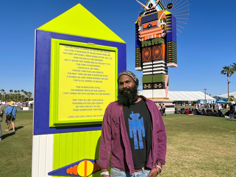 Kumkum Fernando poses in front of his art installation "The Messengers" at the Coachella Valley Music and Arts Festival on April 22, 2023.