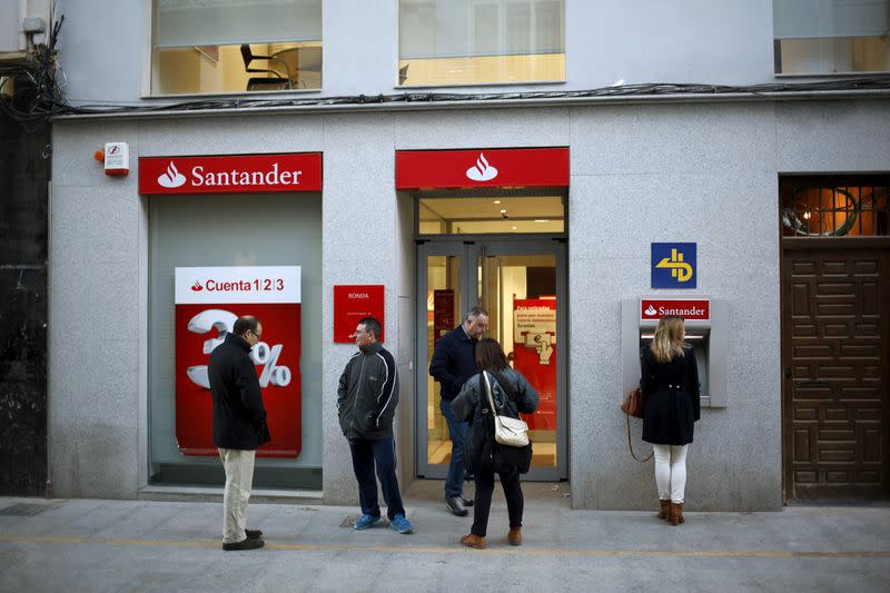 FILE PHOTO: People wait outside a Santander bank branch prior to its opening to the public in downtown Ronda