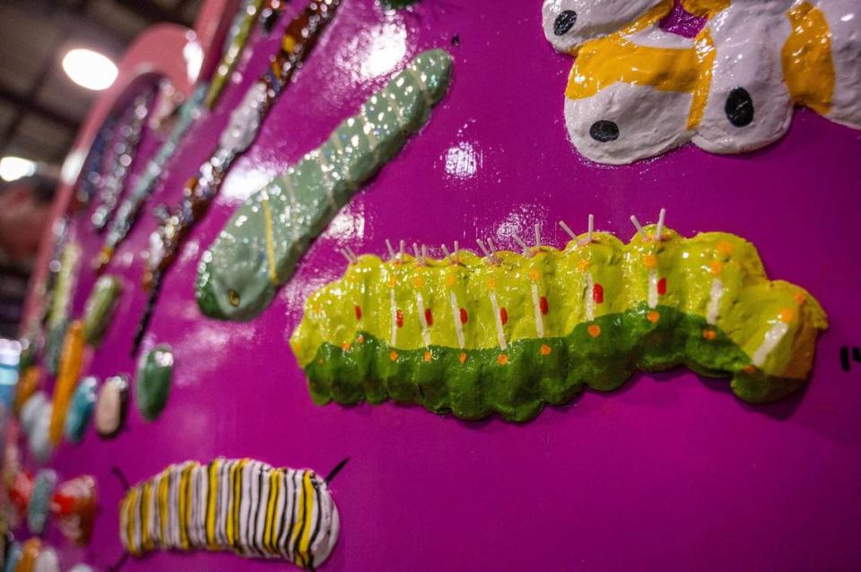 A variety of caterpillars and larvae are seen on the back of the heart titled “Native Butterfly Friends” by artist Miranda Pietzsch Friday during the Parade of Hearts reveal kickoff event. Emily Curiel/ecuriel@kcstar.com