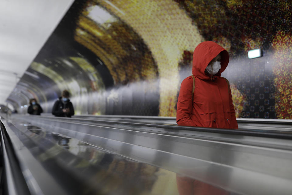 Commuters wearing masks walk in a corridor of the Paris subway Thursday, Oct. 15, 2020 in Paris. French President Emmanuel Macron has announced that millions of French citizens in several regions around the country, including in Paris, will have to respect a 9pm curfew from this Saturday until Dec. 1. It's a new measure aimed at curbing the resurgent coronavirus amid second wave. The measures will require citizens in certain regions where the coronavirus is circulating to be at home after 9pm. (AP Photo/Lewis Joly)