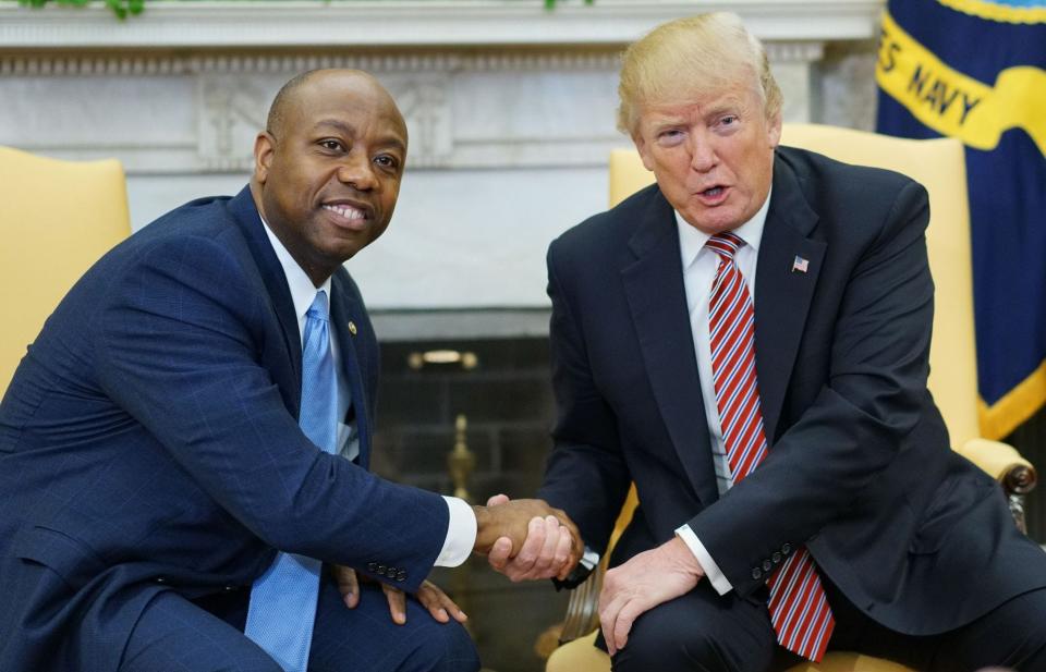 Then-US President Donald Trump and Republican Sen. Tim Scott of South Carolina shake hands following a working session regarding opportunity zones following the recently signed tax bill in the Oval Office of the White House on February 14, 2018 in Washington, DC.