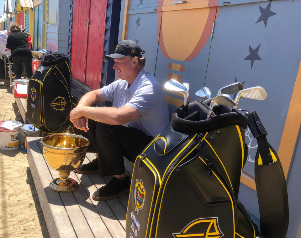 In this Nov. 26, 2018, file photo golfer Ernie Els, captain of the International Team at this year's Presidents Cup, sits in front of a beach house at Brighton in Melbourne, Australia. Royal Melbourne golf course will host the Presidents Cup in December for the third time, and is where the International Team won its only previous tournament against the United States in 1998. (AP Photo/Dennis Passa, FILE)