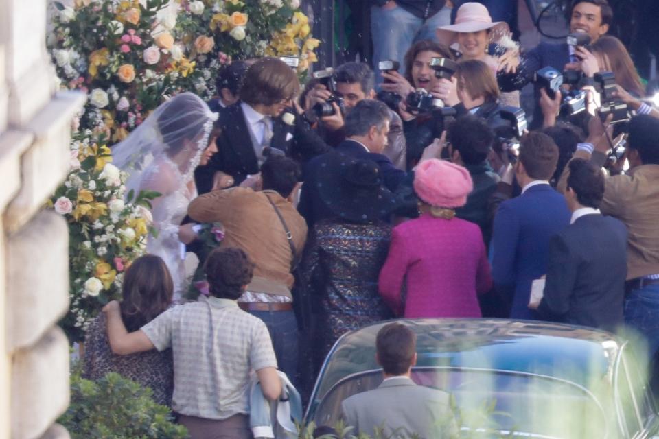 Lady Gaga, wearing a wedding dress in background left, plays Maurizio Gucci's former wife Patrizia Reggiani during the shooting of a movie by Ridley Scott, based on the story of the murder of Maurizio Gucci in 1995, in Rome, Thursday, April 8, 2021. (AP Photo/Andrew Medichini)